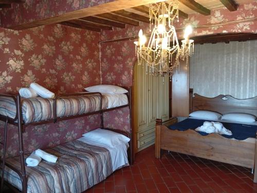 a bedroom with two bunk beds and a chandelier at Albergo ristoranteL'ARCILE in Coreglia Antelminelli