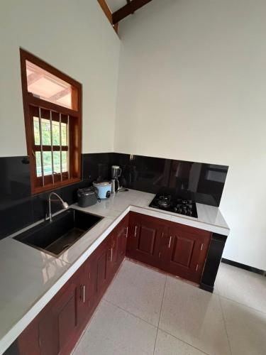 a kitchen with a sink and a stove at Sunny's Hide Out in Talalla South