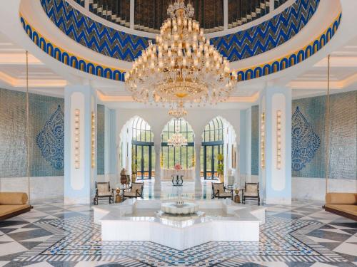 a large lobby with a chandelier and a fountain at Fairmont Udaipur Palace in Udaipur