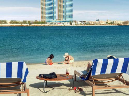 a group of people sitting on the beach at Rixos Obhur Jeddah Resort & Villas - All-Inclusive in Jeddah