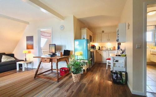 a kitchen and living room with a desk and a refrigerator at Deichhof Whg 27 in Dunsum