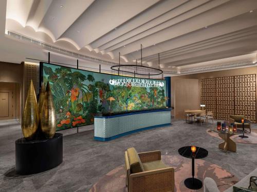 a lobby with a large painting on the wall at Pullman Chennai Anna Salai - Premium Brand By Accor in Chennai