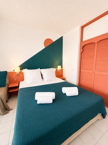 a bedroom with a large bed with two towels on it at Studio Vigie 212 vue mer, accès piscine in Le Diamant