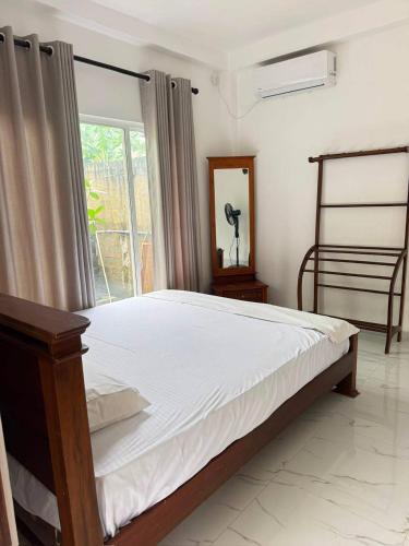 a bedroom with a large bed and a window at Blue Wave Holiday Villa in Weligama