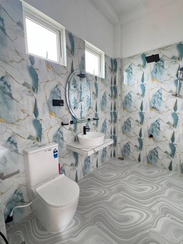 a bathroom with a toilet and a sink at Blue Wave Holiday Villa in Weligama