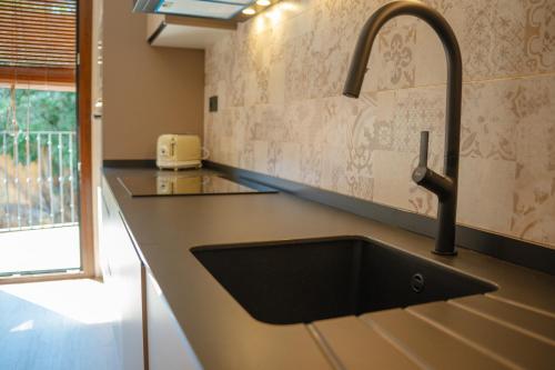 a kitchen with a black sink and a window at Casa 'El Tio Pedro' in Alcañiz