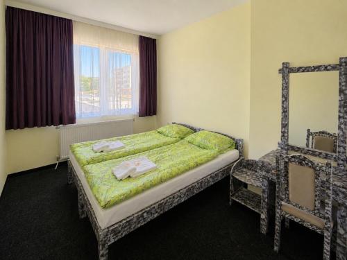 a bedroom with a bed and a mirror and a window at Семеен Хотел ,,Царева Ливада'' in Tsareva Livada