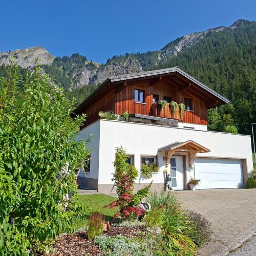 a house with mountains in the background at Haus Adrian in Wald am Arlberg