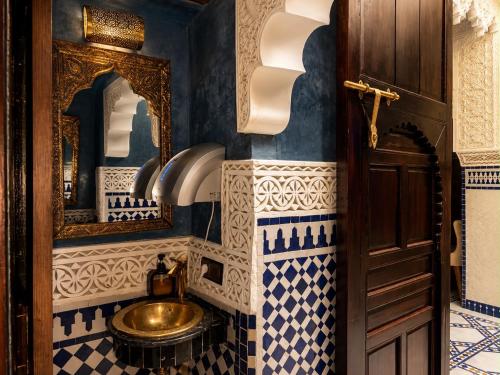 a bathroom with blue and white tiles and a sink at Dar Laabi - Riad Aya in Fez