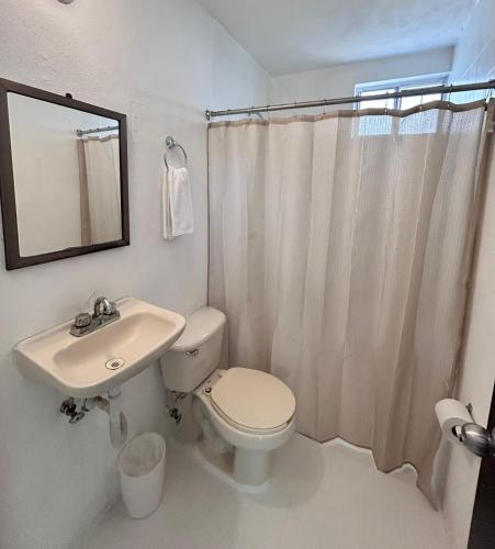 a bathroom with a toilet and a sink and a mirror at Casa Balam Cayo Lobo in Cancún