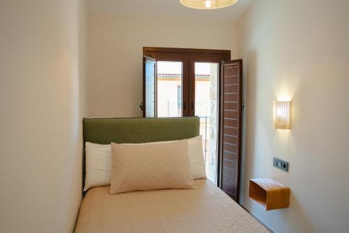 a bedroom with a bed with a pillow and a window at Casa 'El Tio Pedro' in Alcañiz