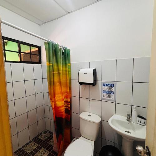 a bathroom with a toilet and a sink at LA CASONA SV Hostal in La Libertad