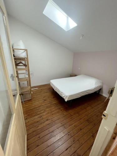 a bedroom with a bed and a wooden floor at Saint Blaise in Les Herbiers