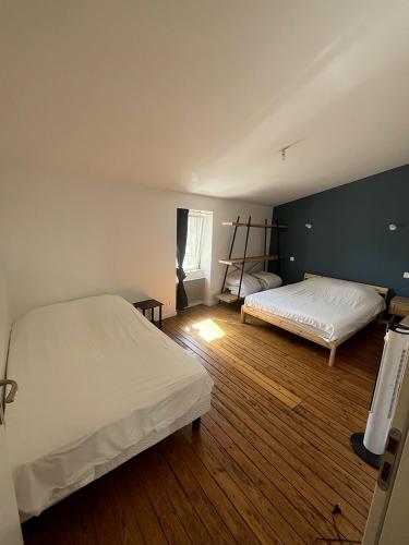 a bedroom with two beds and a green wall at Saint Blaise in Les Herbiers