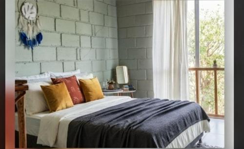a bedroom with a bed with colorful pillows at CO Casa Ocean in Juan de Acosta