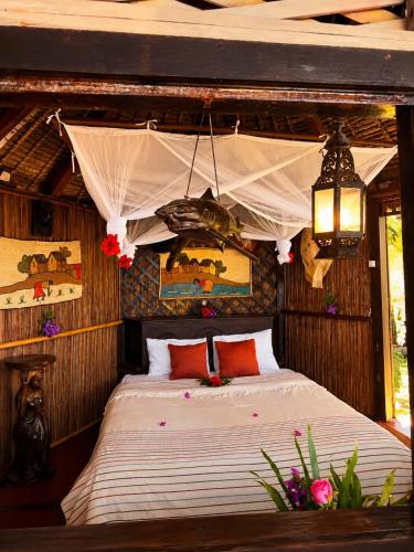 a bedroom with a bed in a hut at Analatsara Eco Lodge in Ile aux Nattes