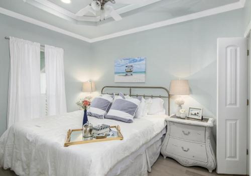 a white bedroom with a bed with a tray on it at 4BR Near the BeachFire PitFamily Friendly Stay in Bolivar Peninsula