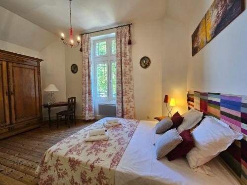 a bedroom with a large bed and a desk at Aux grilles du Château de Saint-Aignan, à 2km de Beauval, les maisons de Sidonie et Léonard in Saint-Aignan