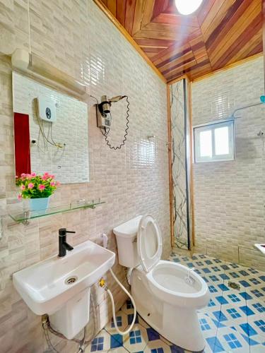 a bathroom with a white toilet and a sink at Bisso Hotel Bonaberi in Douala