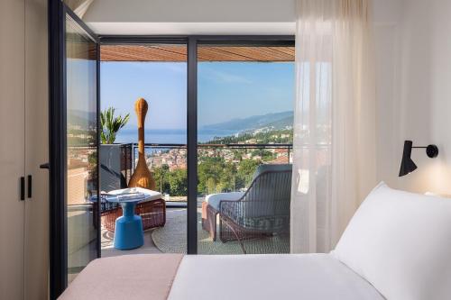 a bedroom with a bed and a balcony with a view at Aminess Younique Vollo Hotel Residences in Opatija