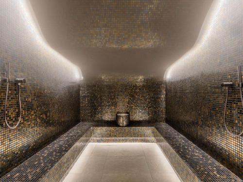 a bathroom with a shower with tiled walls at Mövenpick Hotel & Residences Teuta Kotor Bay in Kotor
