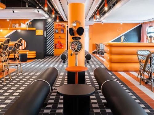 a barbershop with a table and chairs and a clock at ibis Styles La Rochelle Centre les Minimes in La Rochelle