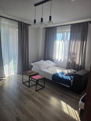 a bedroom with a bed and a coffee table in it at Apartament Stokrotka in Olszyny