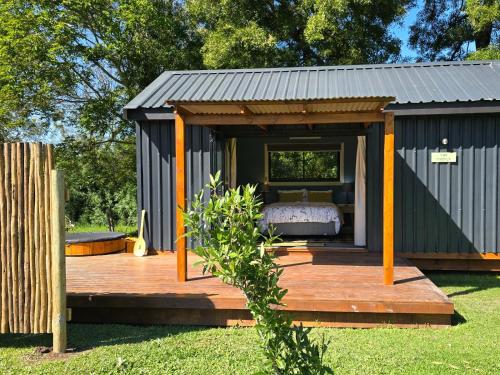 a small shed with a bed on a wooden deck at Moss & Moon Cabins in Stormsrivier