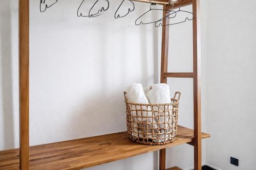 a basket on a wooden shelf with towels at Private Villa, Castel in Lamentin