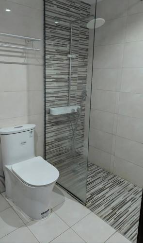 a bathroom with a toilet and a glass shower at Dream International City Homes in Dubai