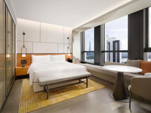a bedroom with a bed and a table and a couch at Pullman Ambassador Seoul Eastpole in Seoul