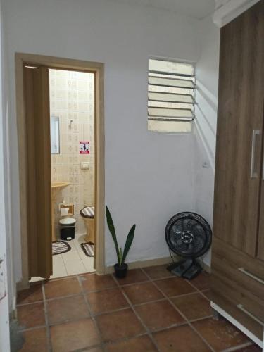 a hallway with a room with a toilet and a window at KaDinizHouse in Caraguatatuba