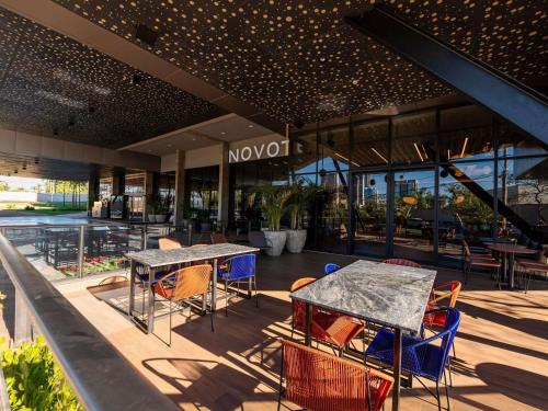 a patio with tables and chairs in front of a building at Novotel Uberlândia in Uberlândia