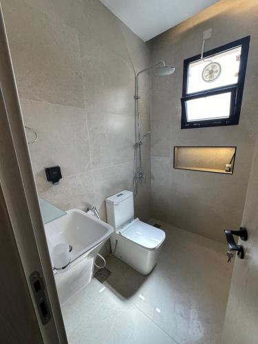 a bathroom with a white toilet and a sink at The Pearl Inn in Nizwa