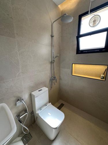a bathroom with a toilet and a sink and a window at The Pearl Inn in Nizwa