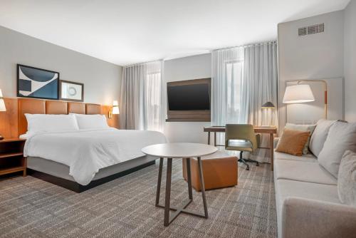 a hotel room with a bed and a couch at Staybridge Suites Crestview South by IHG in Crestview