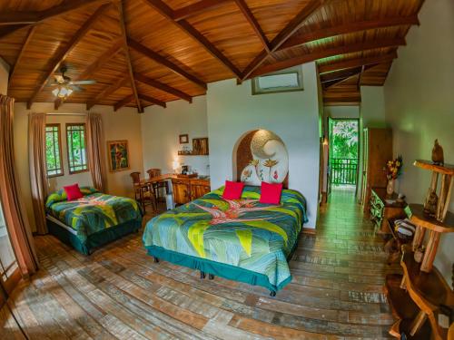 a bedroom with two beds and a wooden ceiling at Lost Iguana Resort and Spa in Fortuna