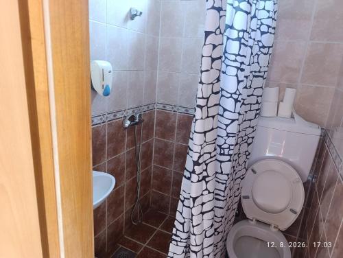 a bathroom with a toilet and a shower curtain at Pit - Stop 
