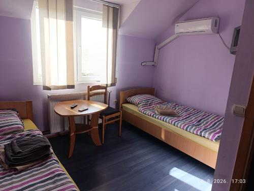 a room with two beds and a table and a window at Pit - Stop 
