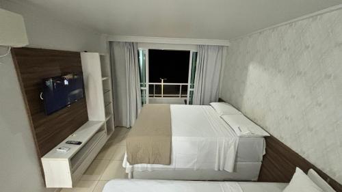a hotel room with a bed and a television at Blue Sunset Experince - Cabo Branco in João Pessoa