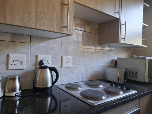 a kitchen with a stove top with a tea kettle at Serene Pastures in Midrand