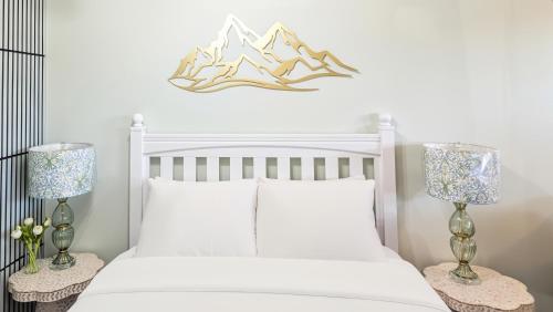 a bedroom with a white bed with two lamps at Sunny Crest Burnaby-cozy one bedroom private suite in Burnaby