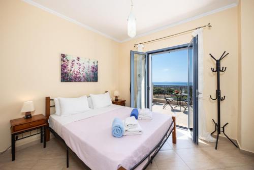 a bedroom with a bed and a view of the ocean at Villa Xenia in Karavádhos