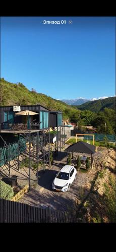 a white car parked in front of a house at SkyCamp Almaty in Almaty