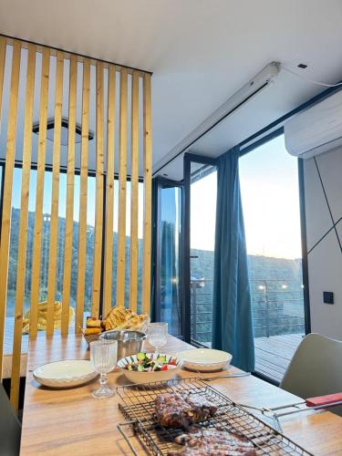 a dining room with a table and a large window at SkyCamp Almaty in Almaty