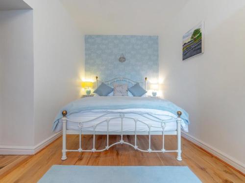 a bedroom with a white bed with blue sheets at 1 Bed in Ambleside oc-lr036 in Ambleside