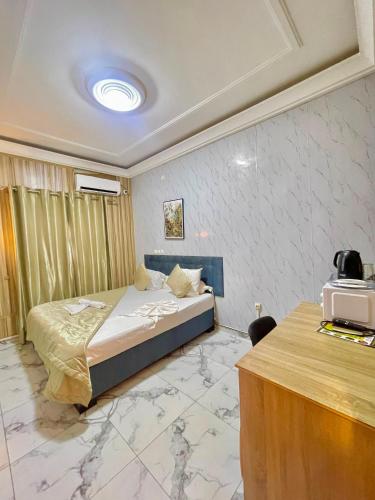a hotel room with a bed and a desk at Bisso Hotel Bonaberi in Douala