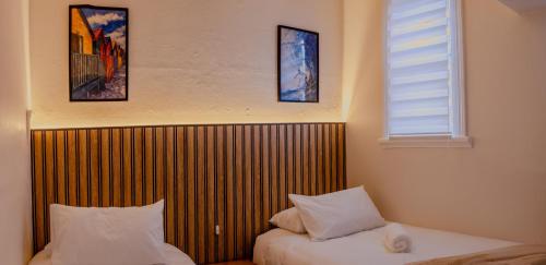 a bedroom with two beds and a window and two pillows at Sand In My Shoes in Muizenberg