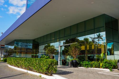 a large glass building with trees in front of it at Hotel Gran Santa Catarina in Indaial