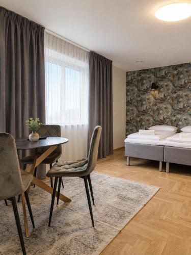 a bedroom with a bed and a table and chairs at Saules apartment Klaipeda in Klaipėda